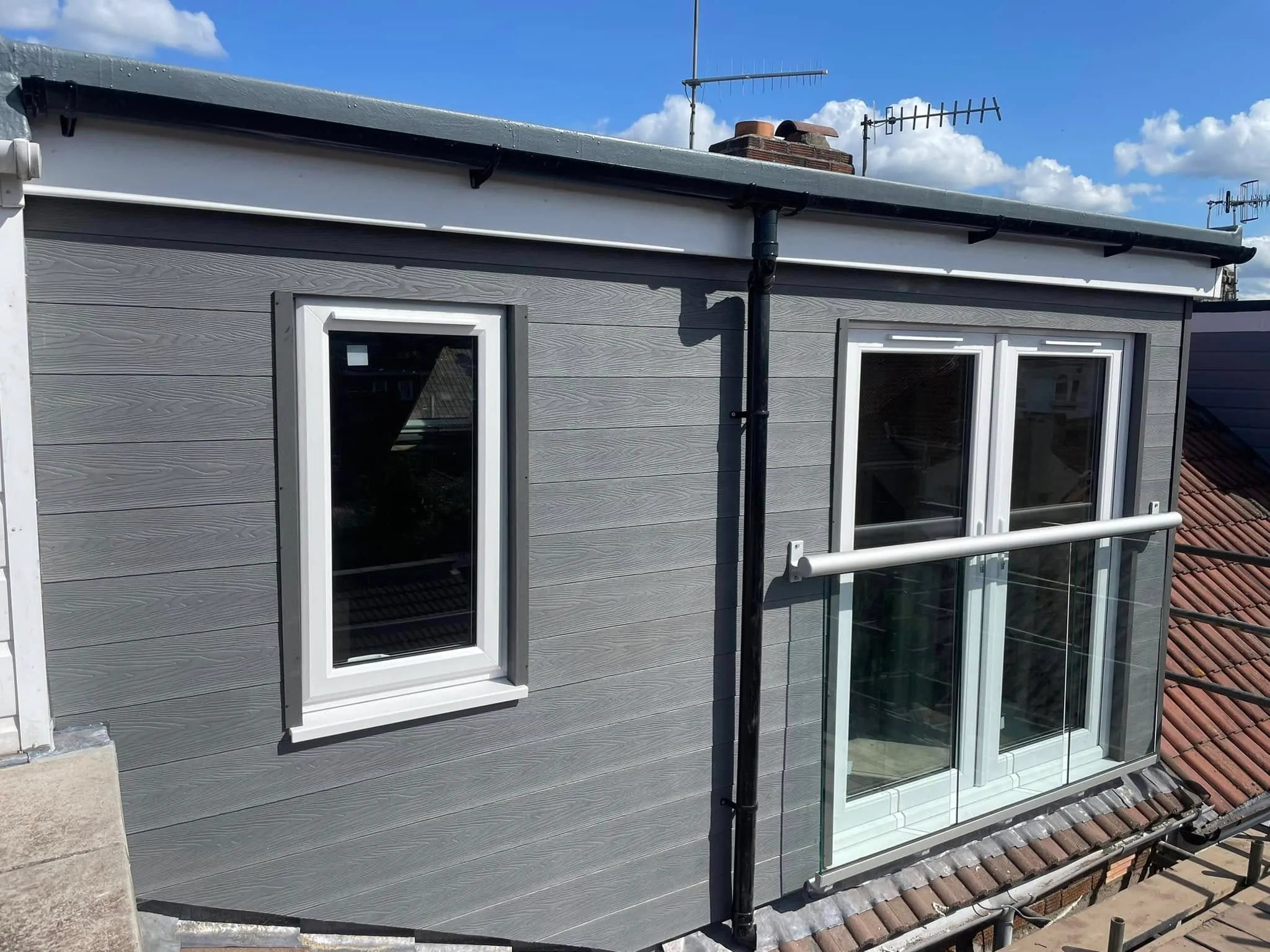 A small house with a metal roof and windows.