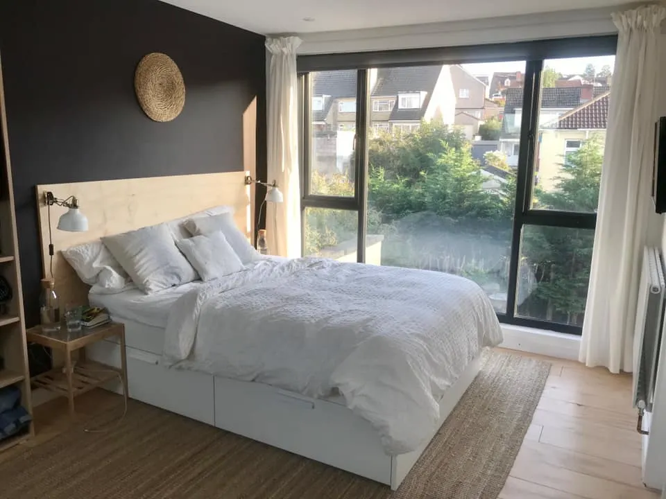 a bedroom with a large bed and a large window