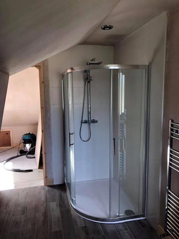 a walk in shower sitting inside of a bathroom