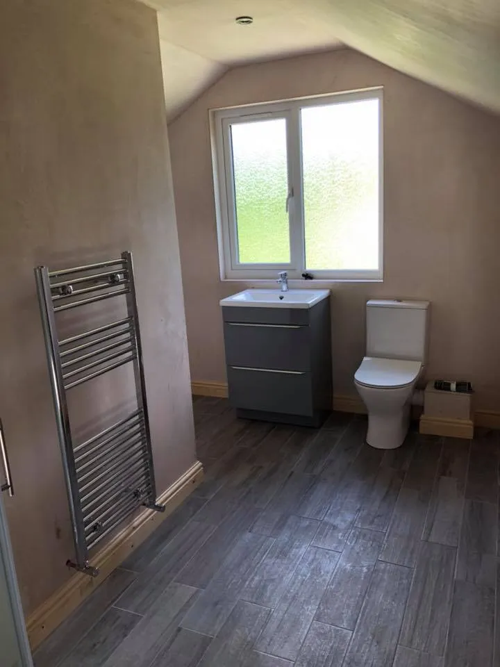 a bathroom with a toilet, sink and a window