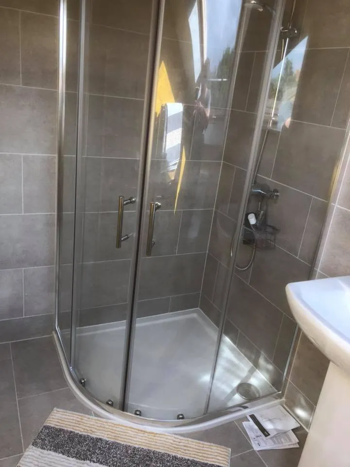 a bathroom with a walk in shower next to a sink