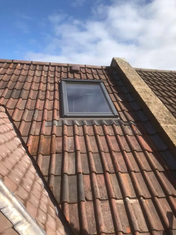 a roof with a window and a sky background