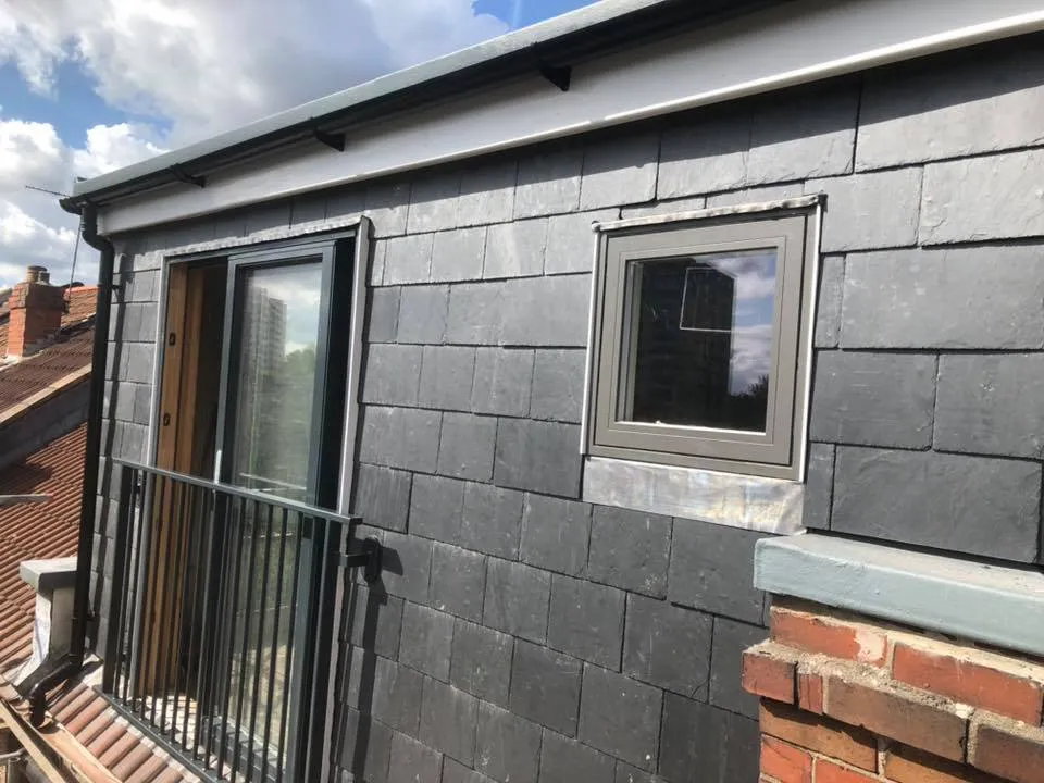 a small house with a metal fence and windows