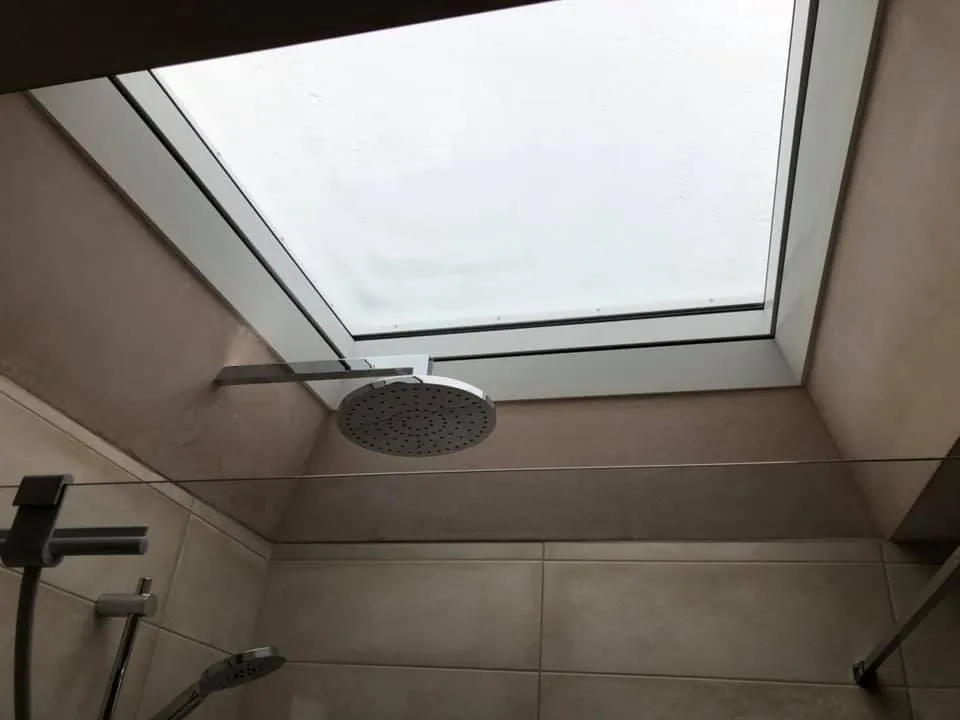 a shower with a skylight in a bathroom